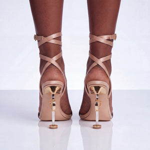 Beige strappy high-heeled shoes on a white background