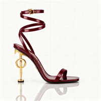 Maroon high-heeled sandal with gold accents on a white background