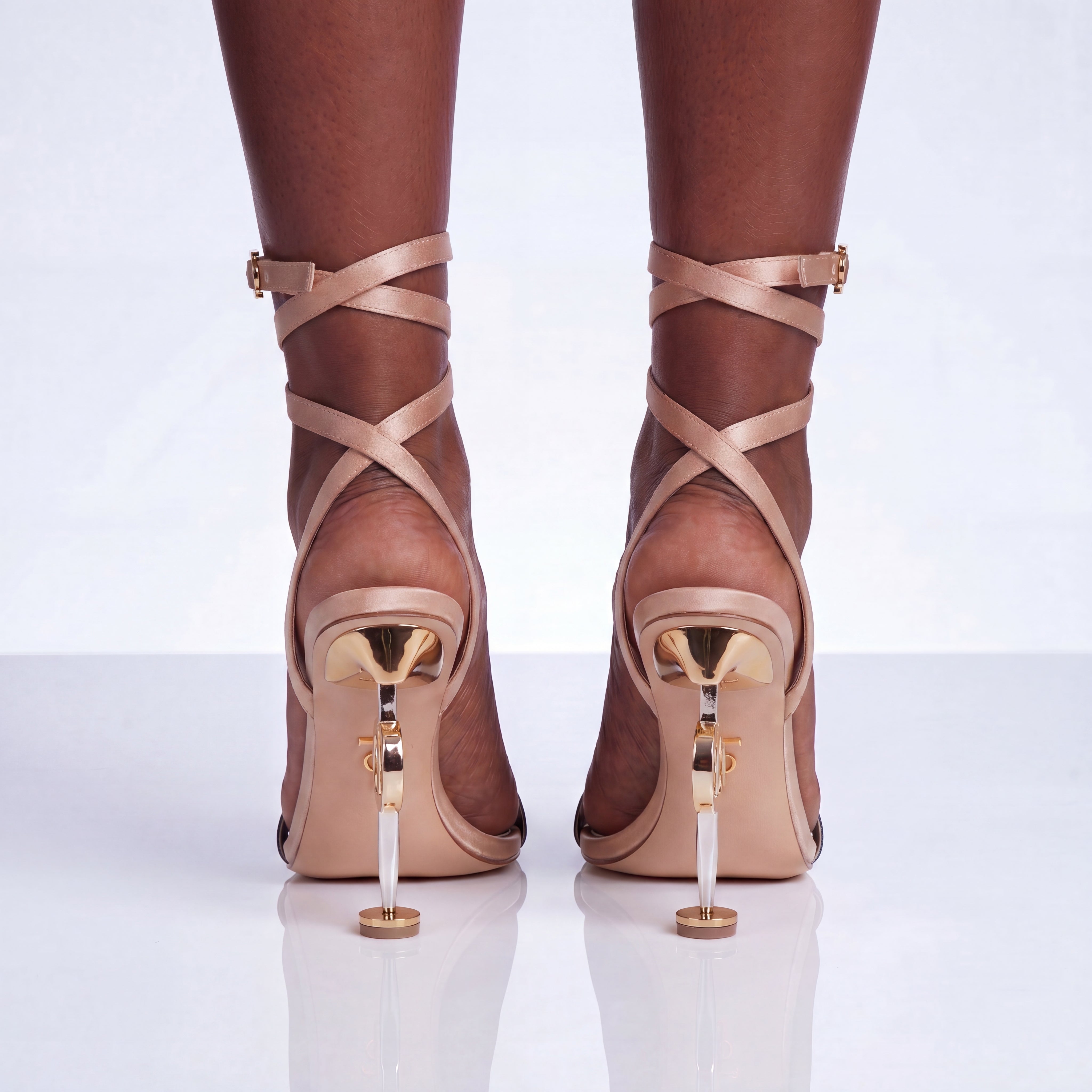 Beige strappy high-heeled shoes on a white background